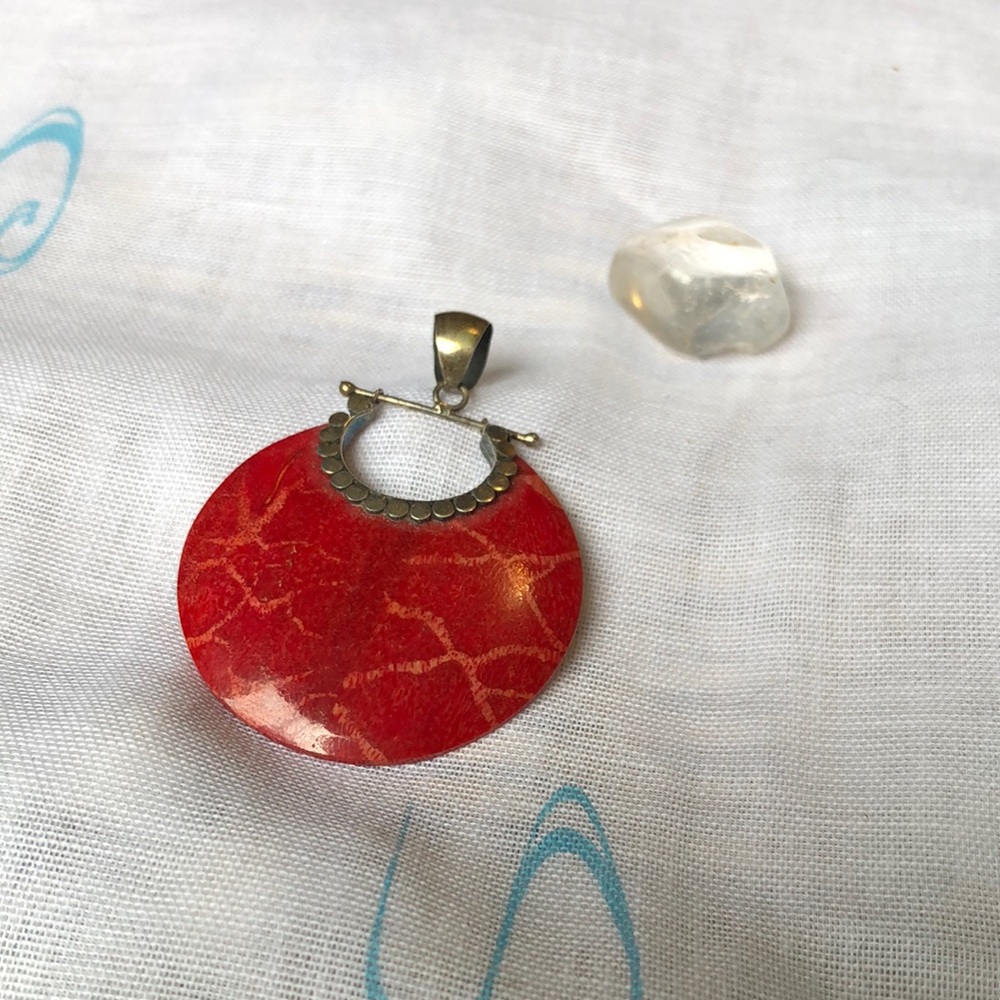 Round polished red pendant with metal findings.